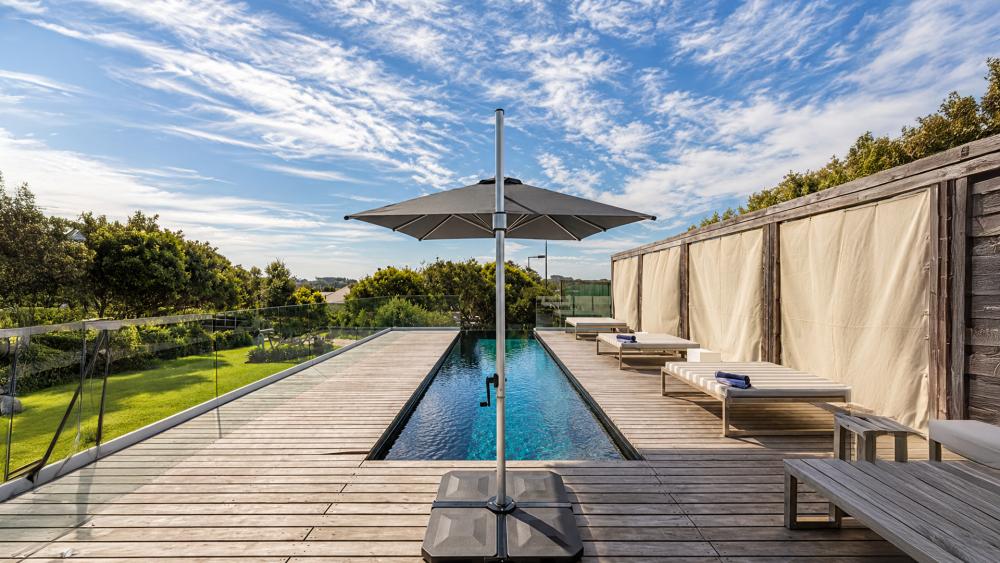 Cantilever outdoor umbrella shading a dining setting in an Australian backyard