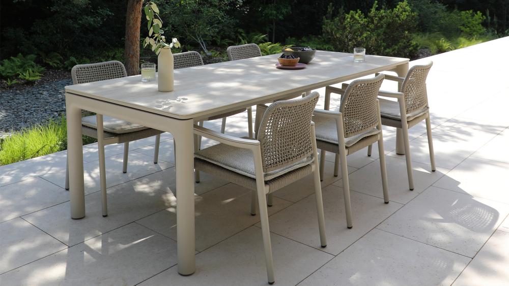 Outdoor dining setting with a ceramic-top table and aluminium chairs on an alfresco patio