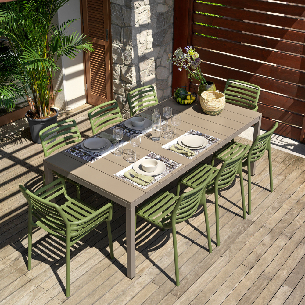 Nardi Doga resin armchairs in agave green around an outdoor dining table on a timber deck